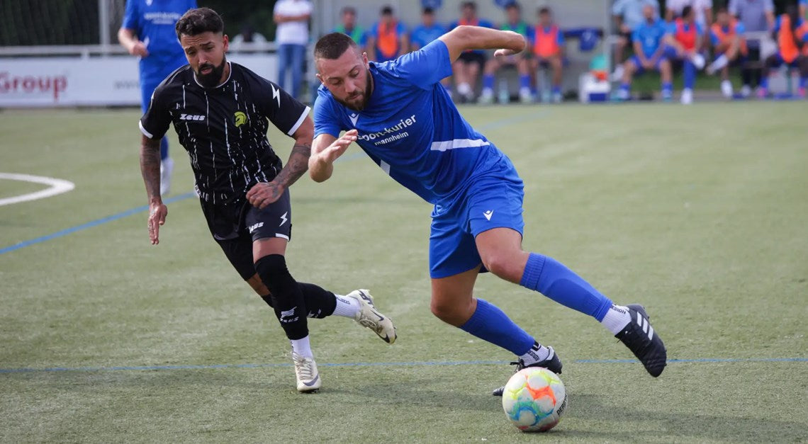 Zwei Fußballspieler im Zweikampf um den Ball auf dem Spielfeld