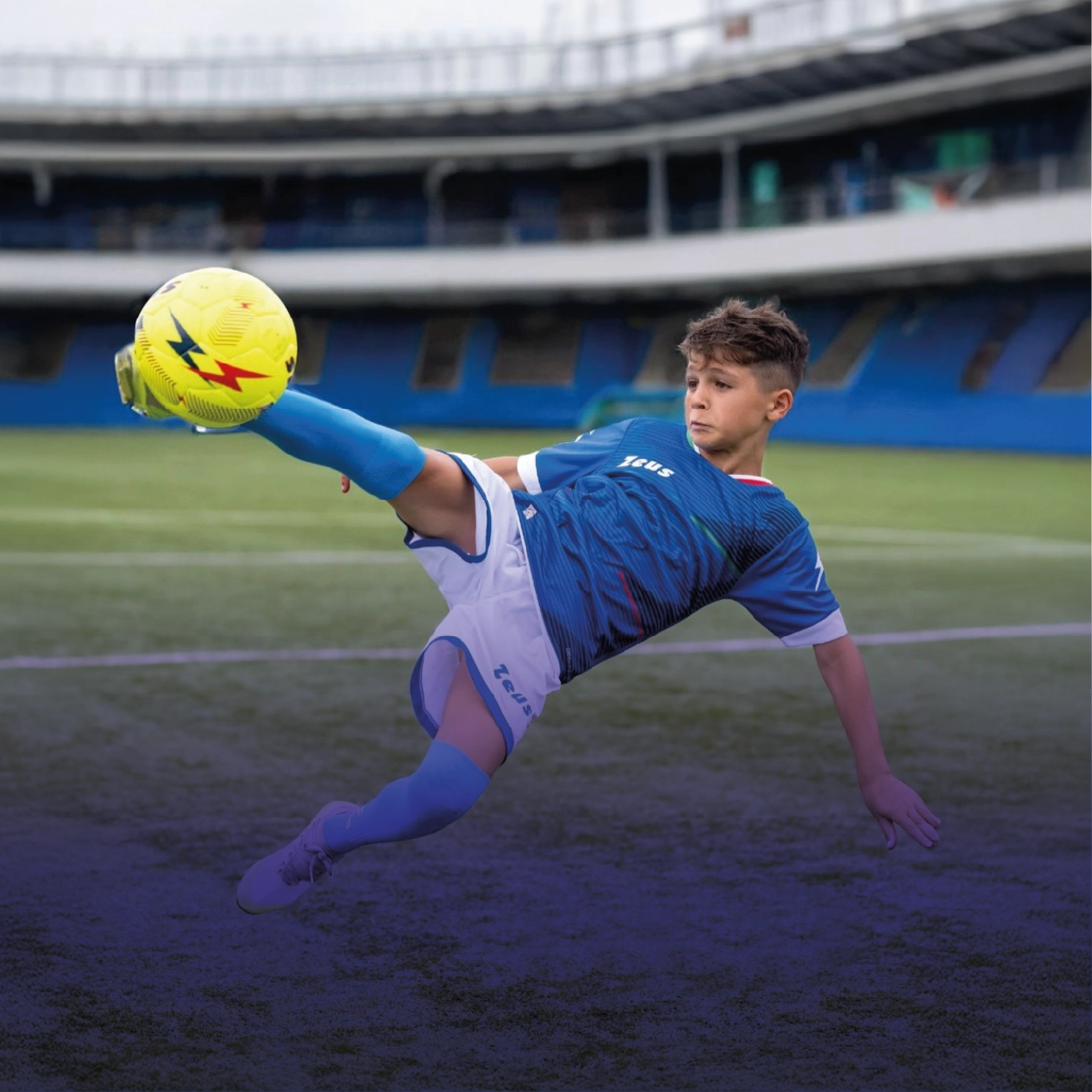 Junger Fußballspieler führt einen Fallrückzieher auf dem Spielfeld aus