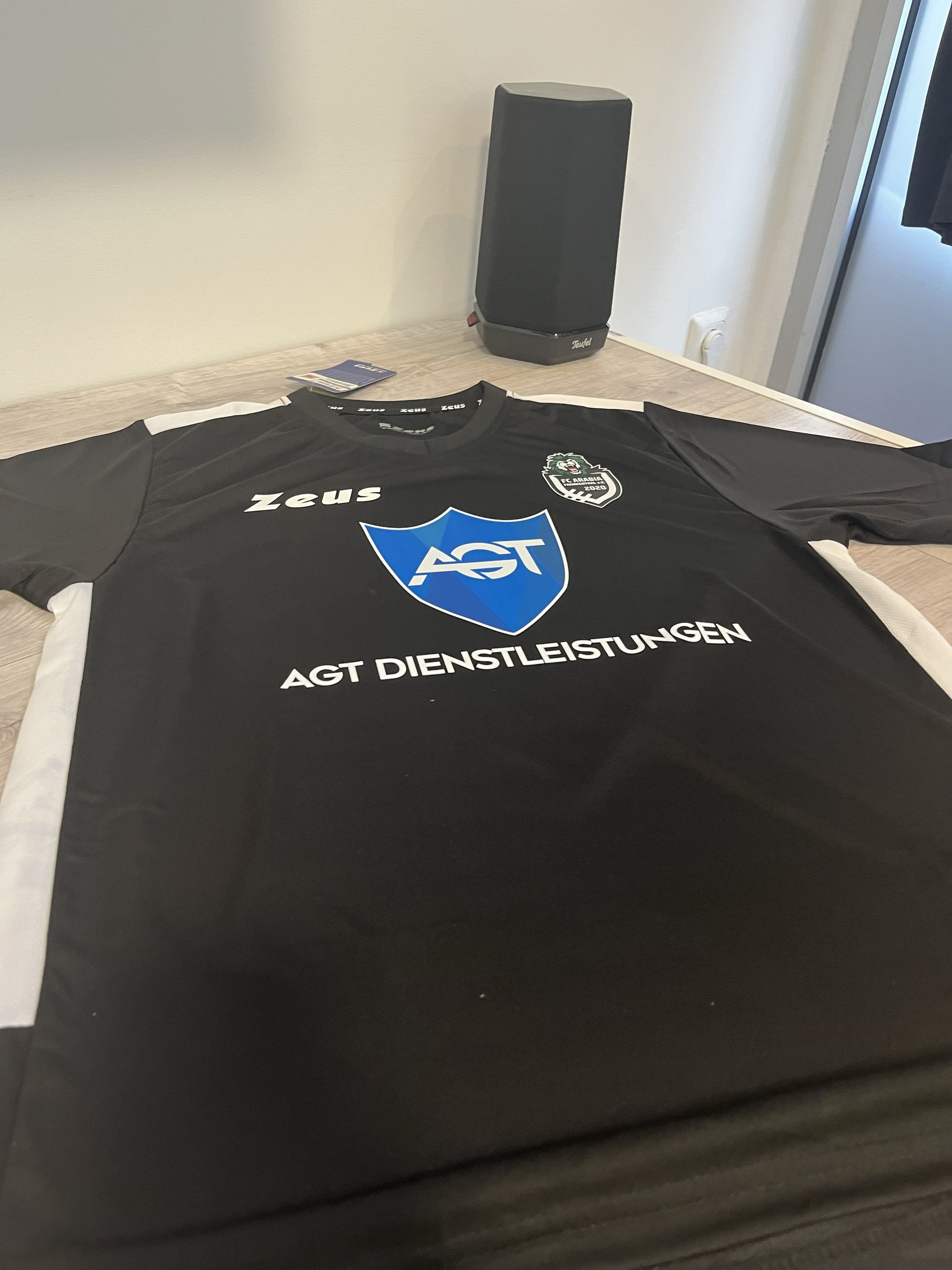 Schwarzes Trikot mit blauem Aufdruck von AGT Dienstleistungen