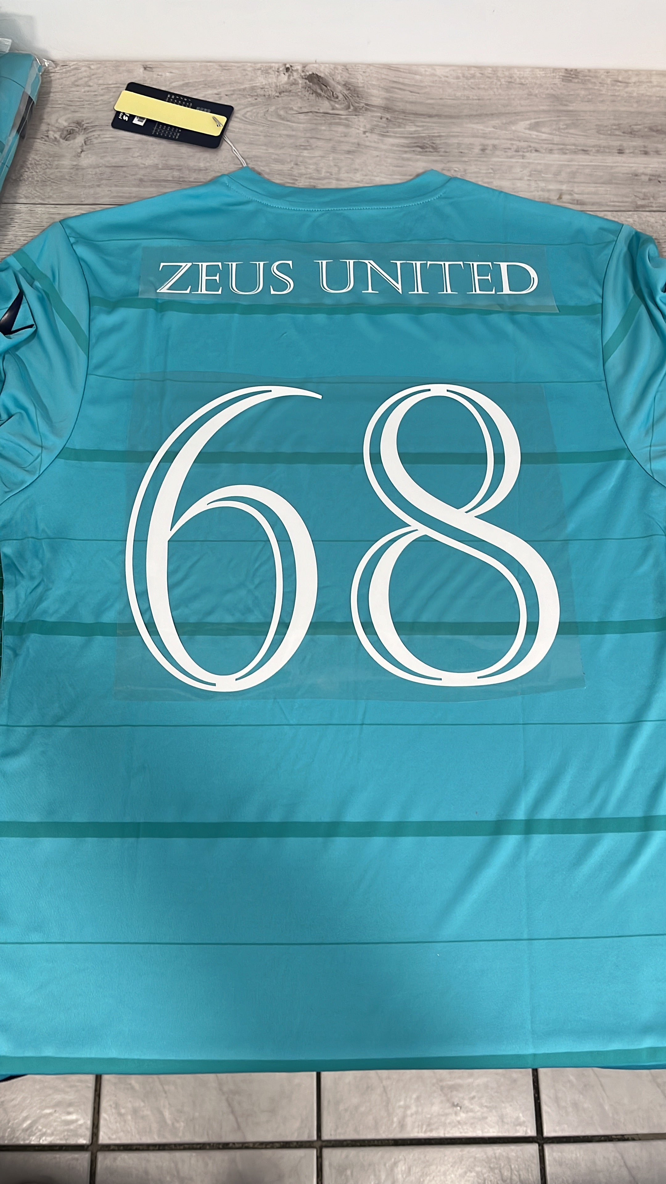 Rückseite eines Hellblaues T-Shirts mit Aufdruck Name und Nummer